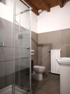 a bathroom with a toilet and a glass shower at Rho appartamento in centro in Rho