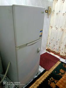 een oude koelkast in een kamer met een gordijn bij شقة مفروشة للايجار in Damietta