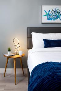 The Lauderdale Boutique Hotel في فورت لاودردال: غرفة نوم مع سرير وطاولة مع بطانية زرقاء