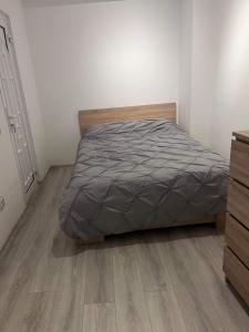 a bedroom with a bed and a wooden floor at NEW APARTAMENT in Drobeta-Turnu Severin