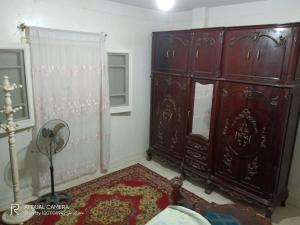 een slaapkamer met een grote houten dressoir in een kamer bij شقة مفروشة للايجار in Damietta