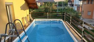 a swimming pool on a balcony with an umbrella at Kuća za odmor- Milošev Konak Banja Luka in Novi Kovići