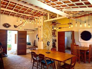 a dining room with a wooden table and chairs at Casa Ana Frank in Parajuru