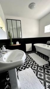 a bathroom with a sink and a tub and a toilet at Agréable maison de ville 