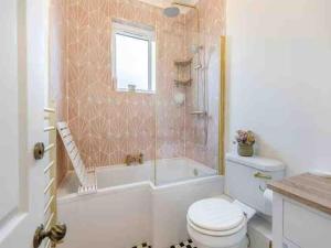 a bathroom with a toilet and a tub and a sink at The Railway Cottage - Stylish & Dreamy Home in the Heart of Whitstable in Kent