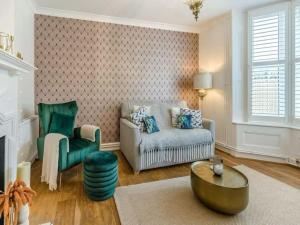 a living room with a couch and a chair at The Railway Cottage - Stylish & Dreamy Home in the Heart of Whitstable in Kent