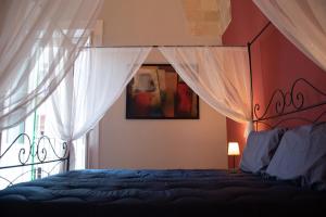 1 dormitorio con cama con dosel y ventana en Arabesque Luxury Apartment - Roof Garden, en Taranto