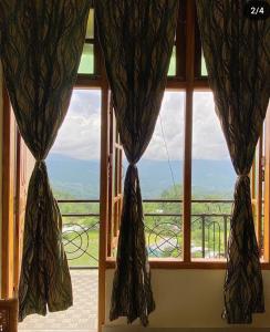 a window with curtains and a view of a balcony at Olivehomestay in Kohīma