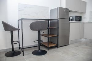 eine Küche mit einem Schreibtisch, 2 Stühlen und einem Kühlschrank in der Unterkunft Arabesque Luxury Apartment - Roof Garden in Taranto + 13 Fotos