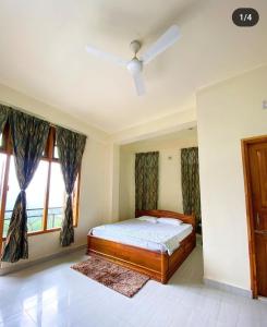 a bedroom with a bed and a ceiling fan at Olivehomestay in Kohīma