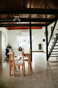 a dining room with a table and chairs and a staircase at Casa Tipo Loft- Tigre Centro in Tigre