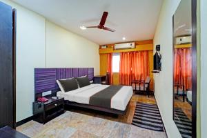1 dormitorio con 1 cama y ventilador de techo en Collection O 81666 Cedar Hotel, en Kāndūr