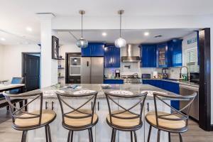 una cucina con armadi blu e tavolo con sedie di Beautiful Clearwater home! a Clearwater