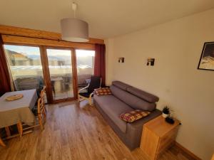 a living room with a couch and a table at Appartement 4 personnes 32m2 Au pied des pistes- WiFI- Balcon Sud- Chamrousse 1650 in Chamrousse