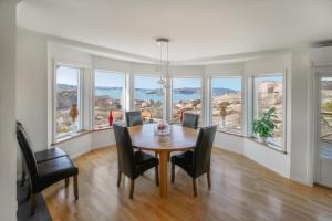 a dining room with a table and chairs and windows at Charming Villa Retreat by AJF Dream Living in Fjällbacka