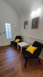 a room with two chairs and a table with yellow pillows at GIO&GIO central house in Palermo