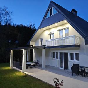 a large white house with a deck and a patio at My sweet home Vrhpraca Jahorina in Jahorina