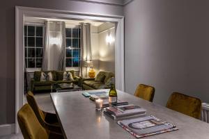 a dining room table with a bottle of wine on it at Shared Guest House 5 mins walk from Vauxhall and Nine Elms Station with off-site parking near US embassy in London
