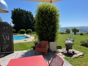 a patio with a table and chairs and a pool at Domaine des Pierres D Auvergne in Flat