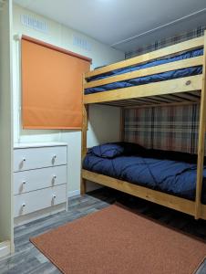 a bedroom with two bunk beds and a dresser at The Piggery in Witheridge