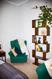 a living room with a green chair and a book shelf at Apartament w Złotym Stoku Przystanek Las in Złoty Stok