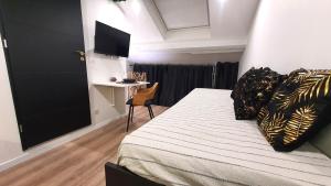 a bedroom with a bed and a table with a chair at Le Green : Studio centre-ville*proche gare*parking in Vesoul