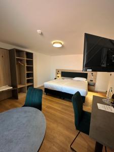 um quarto com uma cama e uma televisão de ecrã plano em Hopfenhotel am Adenauerufer em Bamberg