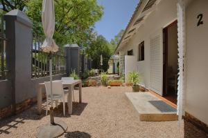 a patio with a table and an umbrella next to a building at The River Guestroom in Krugersdorp