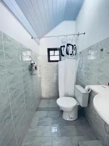 a white bathroom with a toilet and a sink at Pousada do Sol in Rio de Janeiro