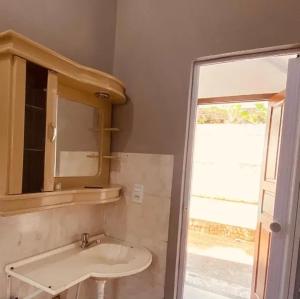 a bathroom with a sink and a mirror and a window at Pousada do Sol in Rio de Janeiro