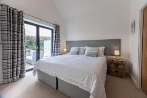 a bedroom with a large bed and a large window at Attractive pet friendly beach house in Westward Ho in Westward Ho