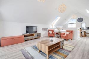 a living room with a couch and a tv at Attractive pet friendly beach house in Westward Ho in Westward Ho