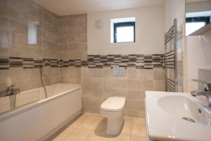 a bathroom with a tub and a toilet and a sink at Attractive pet friendly beach house in Westward Ho in Westward Ho