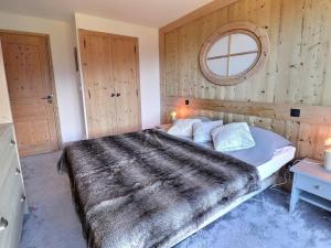 a bedroom with a large bed and a mirror at Charmant 2 pièces cabine skis aux pieds, parking inclus - FR-1-182-245 in Les Allues