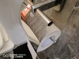 a toilet with its door open in a bathroom at Rajarata Lodge in Anuradhapura