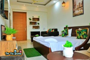 ノイダにあるThe Taj Studios-Best HomeStay Couple Friendly In Central Noida #NorthEyeのベッドルーム1室(ベッド1台付)、リビングルームが備わります。