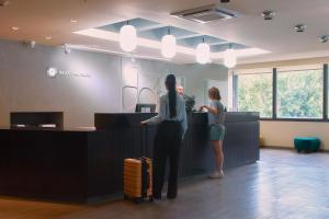 two women standing at a counter in an office with luggage at Hotel Raices Aconcagua in Mendoza