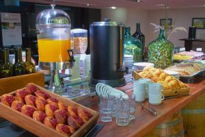 un bancone con bar con pane, succhi di frutta e cibo di Hotel Raices Aconcagua a Mendoza