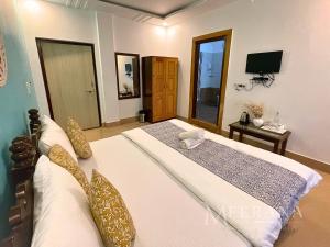 ein Schlafzimmer mit einem großen Bett und einem TV in der Unterkunft Hotel Meerana in Jaisalmer
