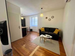 a living room with a couch and a table at Appartement Climatisé 4 personnes / Centre-ville in Besançon