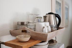 a wooden shelf with cups and utensils on a counter at The River Guestroom in Krugersdorp