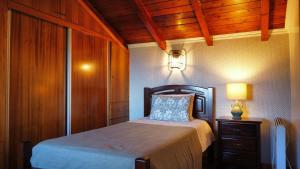 a bedroom with a bed with a lamp and a dresser at fantastic holiday house in Ponta Delgada