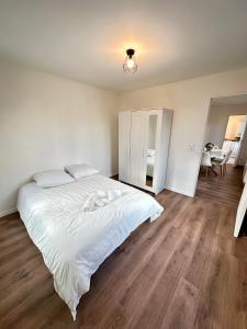 a bedroom with a large white bed and wooden floors at Magnifique apartment in Paris / Bagnolet 101 in Bagnolet