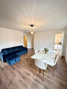 ein Wohnzimmer mit einem Tisch und einem blauen Sofa in der Unterkunft Magnifique apartment in Paris / Bagnolet 101 in Bagnolet