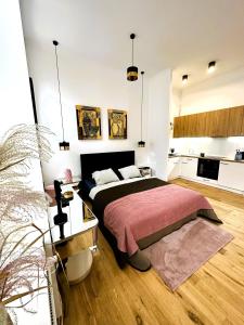 a bedroom with a large bed and a kitchen at Apartamenty Dream Place in Toruń