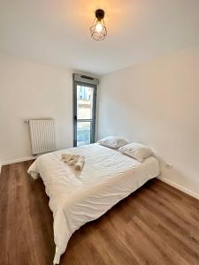 una camera da letto con un grande letto con lenzuola bianche di Magnifique apartment in Paris / Bagnolet 101 a Bagnolet