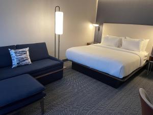 a hotel room with a bed and a couch at Courtyard Montreal Midtown in Montréal