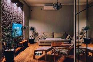 a living room with a couch and some plants at Living Life Apartment Komotini in Komotini