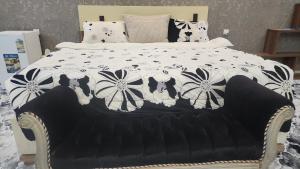 1 cama con edredón blanco y negro con flores en مزرعة واستراحة بستان, en Şāmitah
