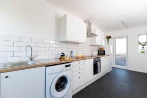 a white kitchen with a washing machine in it at Stanhope House in Stockton-on-Tees